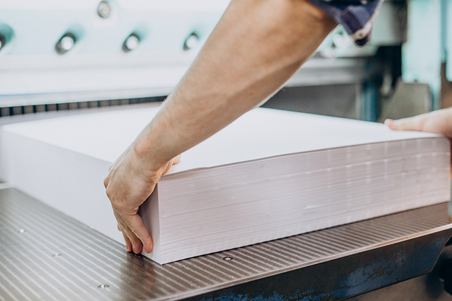 Press-operator-feeding-sheets-to-print-PDFs